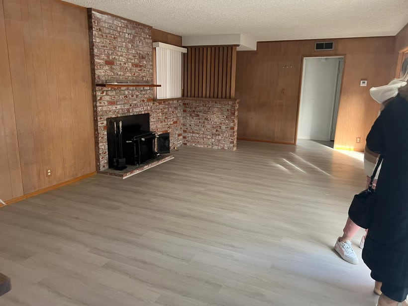 Finished interior flooring installation in a living room with fireplace and wood accent wall